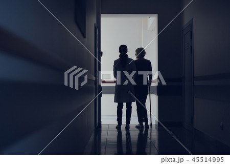 Doctor is leading woman with stick through hallway Doctor is leading woman with stick through hallway 45514995