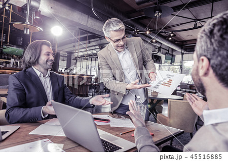 Attentive gray-haired man showing sketch to colleagues 45516885