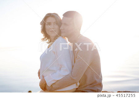 Hugging young couple expecting a first baby Hugging young couple expecting a first baby 45517255