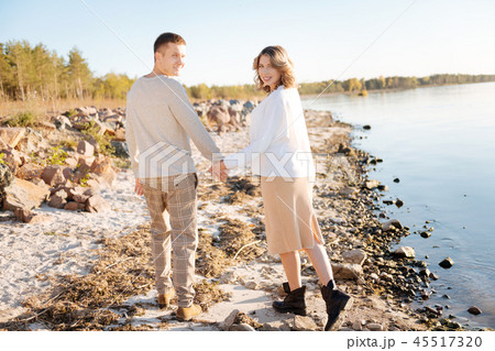 Man and a woman holding hands while walking together 45517320