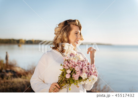 Woman walking with a bunch of flowers outdoor Woman walking with a bunch of flowers outdoor 45517432