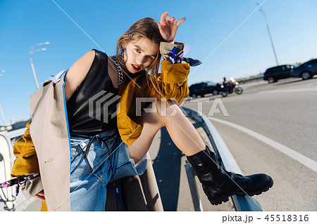 Famous model wearing black leather boots posing outside 45518316