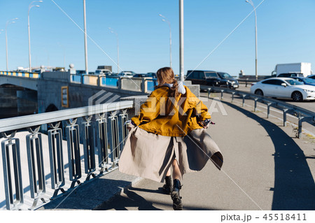 Fashionable dark-haired woman feeling free crossing the bridge Fashionable dark-haired woman feeling free crossing the bridge 45518411