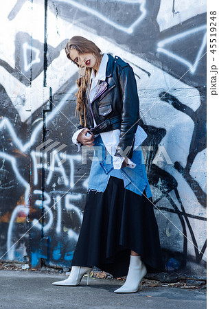 Slim trendy model wearing long baggy denim and black skirt Slim trendy model wearing long baggy denim and black skirt 45519248