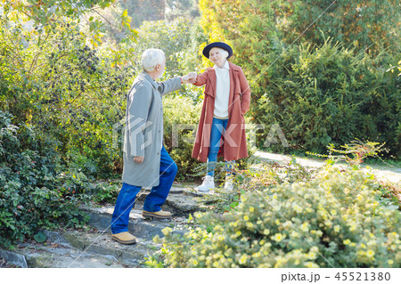 Pleasant gallant man giving a hand to his wife Pleasant gallant man giving a hand to his wife 45521380