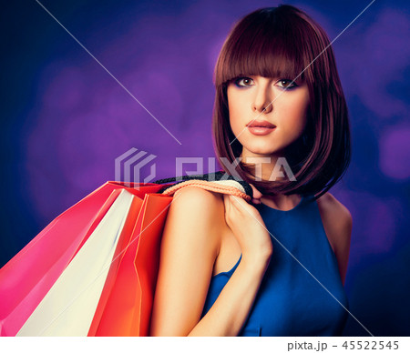 girl with shopping bags on purple background. 45522545