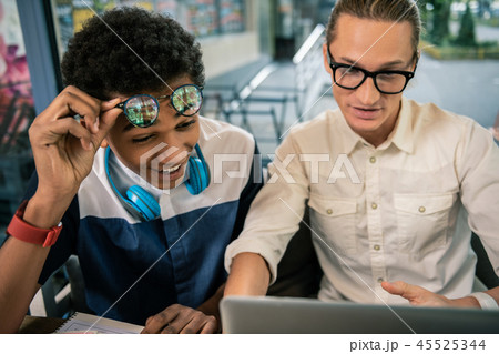 Joyful young man putting his glasses up Joyful young man putting his glasses up 45525344