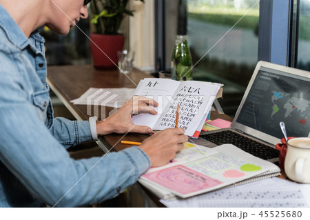 Pleasant young man doing his homework Pleasant young man doing his homework 45525680