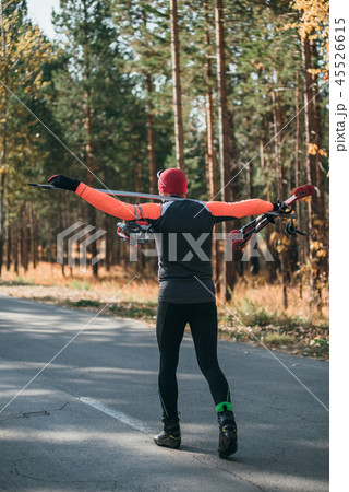 Training an athlete on the roller skaters. Biathlon ride on the roller skis with ski poles, in the Training an athlete on the roller skaters. Biathlon ride on the roller skis with ski poles, in the 45526615