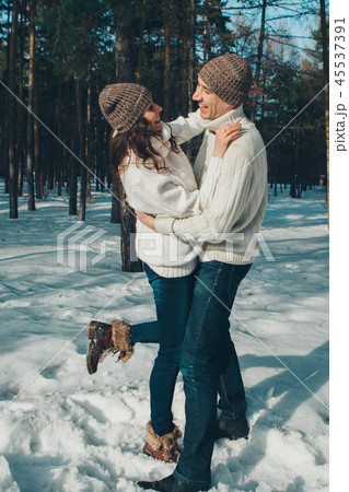 man and woman playing in the snow 45537391