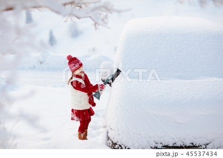 Child brushing off car. Kid with winter snow brush 45537434