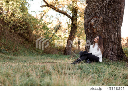 beautiful woman in black hat sitting under big tree beautiful woman in black hat sitting under big tree 45538895