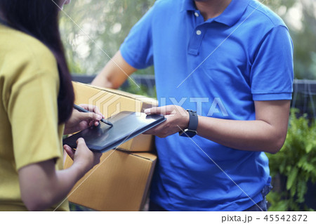 Asian young sign on tablet, delivery man bring box 45542872