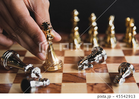 Hand of businessman moving golden chess figure Hand of businessman moving golden chess figure 45542913
