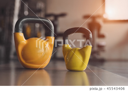 Two colorful kettlebells on fitness gym floor 45543406