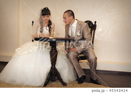 the bride and groom sign the document 45543414