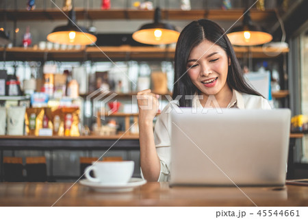 Asian female freelancer doing happy gesture by raising hand when Asian female freelancer doing happy gesture by raising hand when 45544661