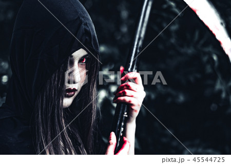 Female demon witch with bloody reaper standing in front of myste 45544725