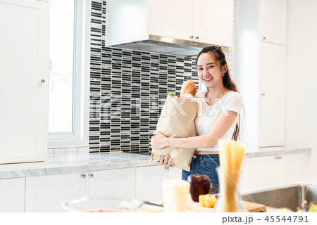 Asian beauty woman holding bag of ingredients for cooking after Asian beauty woman holding bag of ingredients for cooking after 45544791