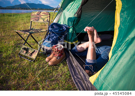 Close up of woman legs relaxing in camping tent with mountain la Close up of woman legs relaxing in camping tent with mountain la 45545084