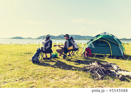 Group of travelers camping and doing picnic and playing music to 45545088