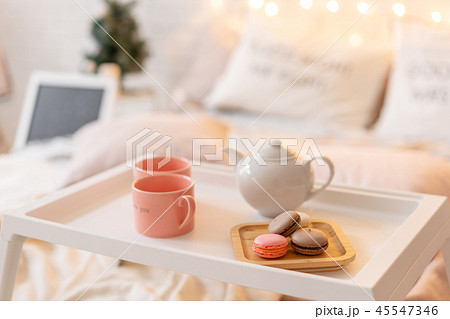 breakfast in bed, tray with cup of coffee and macaroon. Modern bedroom interior. Romantic morning 45547346