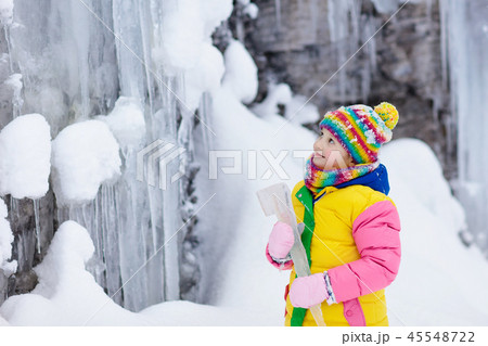 Children play with icicle in snow. Kids winter fun Children play with icicle in snow. Kids winter fun 45548722