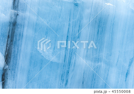 Close-up wall of a centuries-old glacier with a structure of stripes and bubbles. Ice blue light Close-up wall of a centuries-old glacier with a structure of stripes and bubbles. Ice blue light 45550008