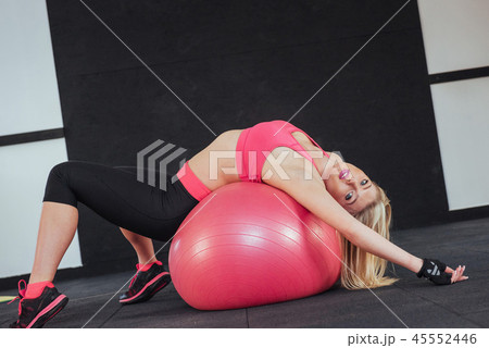 Slender woman in sportswear, doing exercises with the ball Slender woman in sportswear, doing exercises with the ball 45552446