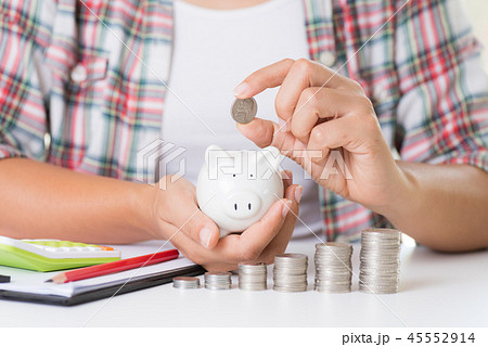 Woman hand putting money coin on stack of coins Woman hand putting money coin on stack of coins 45552914