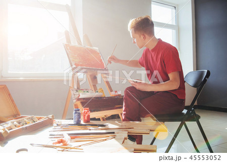 young artist paints a picture in the studio 45553052