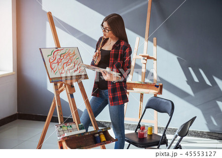 Pretty Pretty Girl artist paints on canvas painting on the easel. 45553127