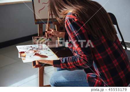 Pretty Pretty Girl artist paints on canvas painting on the easel. 45553179