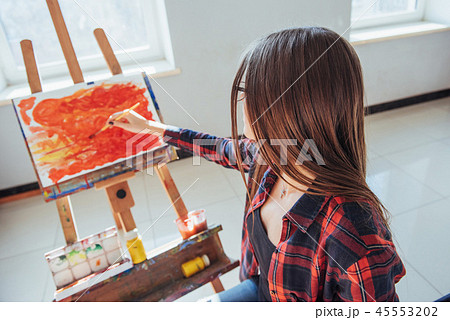 Pretty Pretty Girl artist paints on canvas painting on the easel Pretty Pretty Girl artist paints on canvas painting on the easel 45553202