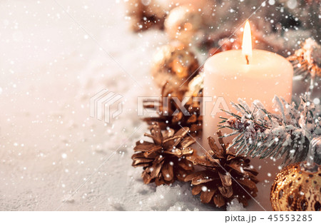 Beige snow Christmas composition. Burning candle and fir cones 45553285