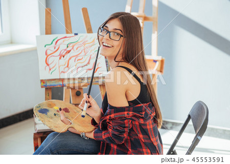 Pretty Pretty Girl artist paints on canvas painting on the easel Pretty Pretty Girl artist paints on canvas painting on the easel 45553591