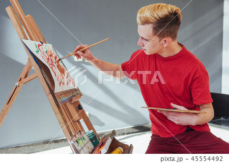 artist painting a picture in a studio artist painting a picture in a studio 45554492