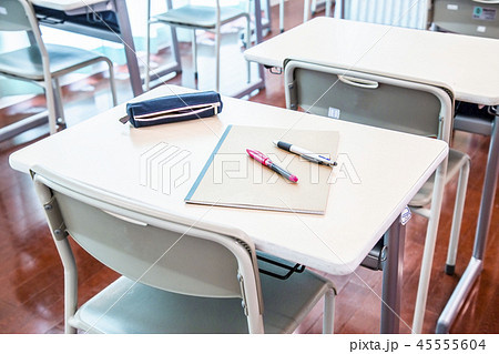 教室に並ぶ机と椅子 机の上のノートとペン スクールイメージ の写真素材