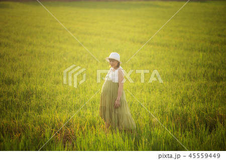 pregnant woman in green dress relaxing in meadow pregnant woman in green dress relaxing in meadow 45559449