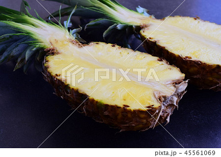 Halves of pineapple on black concrete background. Halves of pineapple on black concrete background. 45561069