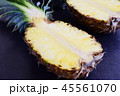 Halves of pineapple on black concrete background. 45561070