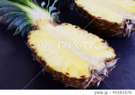 Halves of pineapple on black concrete background. 45561070