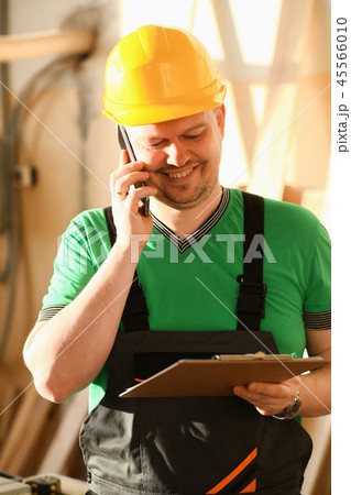 Carpenter talking on phone in hardware store Carpenter talking on phone in hardware store 45566010