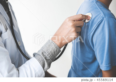 Doctor checking patient with stethoscope listening to heartbeat, 45569114