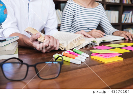 High school or college student group sitting at desk in library 45570104