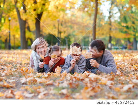 Happy family sit autumn city park on fallen leaves Happy family sit autumn city park on fallen leaves 45572415