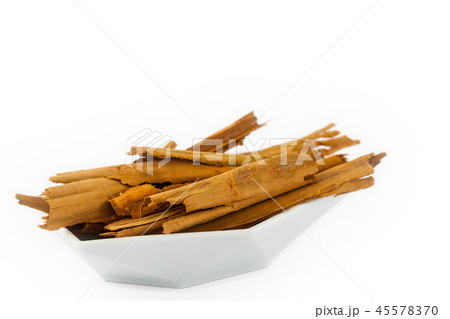 Dry cinnamon sticks in a small white dish isolated Dry cinnamon sticks in a small white dish isolated 45578370