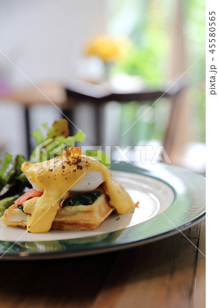 Breakfast food egg benedict , poached egg with yellow sauce with waffle and smoked salmon on wood background 45580565