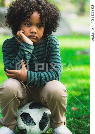 Unhappy little african american kid in the park. 45581832