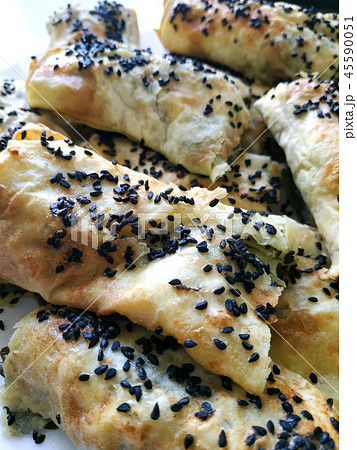 Cutted lavash pieces with vegetables. Burek with spinach and cheese and black cumin. Yufka Cutted lavash pieces with vegetables. Burek with spinach and cheese and black cumin. Yufka 45590051